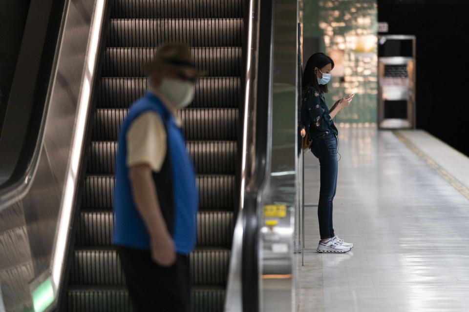 Two commuters wait for a train to arrive at a Metro station in Los Angeles, Wednesday, July 13, 2022. Los Angeles County, the nation's largest by population, is facing a return to a broad indoor mask mandate if current trends in hospital admissions continue, health director Barbara Ferrer told county supervisors Tuesday. (AP Photo/Jae C. Hong)