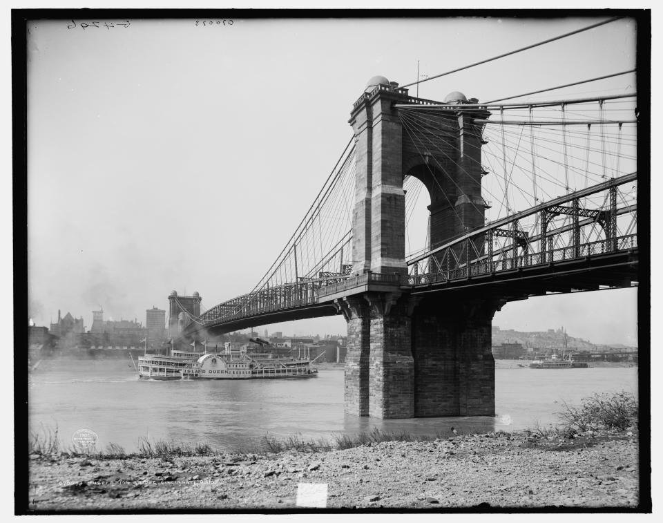 1907: The steamboat Island Queen on the Ohio River passes under the Roebling Suspension Bridge, Cincinnati.