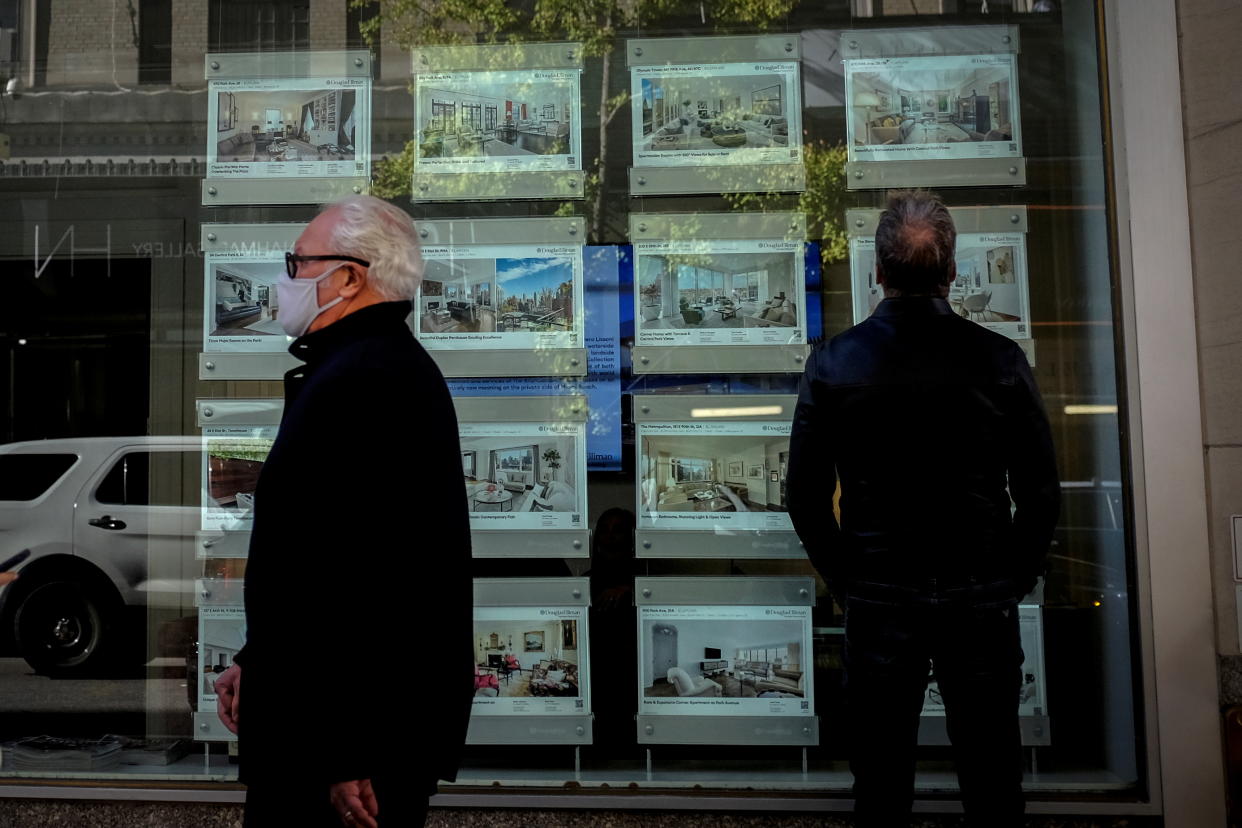 A man looks at advertisements for luxury apartments and homes in the window of a Douglas Elliman Real Estate sales business in Manhattan's upper east side neighborhood in New York City, New York. (Credit: Mike Segar, REUTERS)