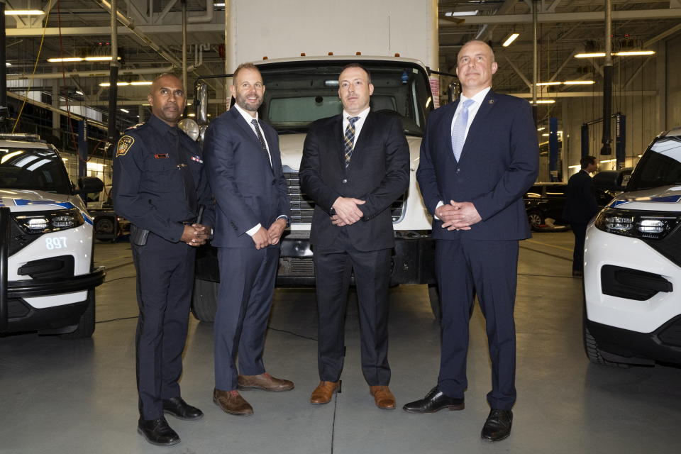 Chief Nishan Duraiappah, left to right, Detective Sergeant Mike Mavity, Peel Regional Police Det. Gord Oakes and ATF Special Agent in Charge, Eric DeGree pose in front of a recovered truck during a press conference regarding Project 24K a joint investigation into the theft of gold from Pearson International Airport, in Brampton, Ontario, on Wednesday, April 17, 2024. (Arlyn McAdorey/The Canadian Press via AP)