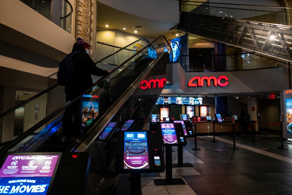 A person wearing a protective mask rides an escalator at the AMC movie theatre in Times Square, amid the coronavirus disease (COVID-19) pandemic, in the Manhattan borough of New York City, New York, U.S., March 6, 2021. REUTERS/Jeenah Moon