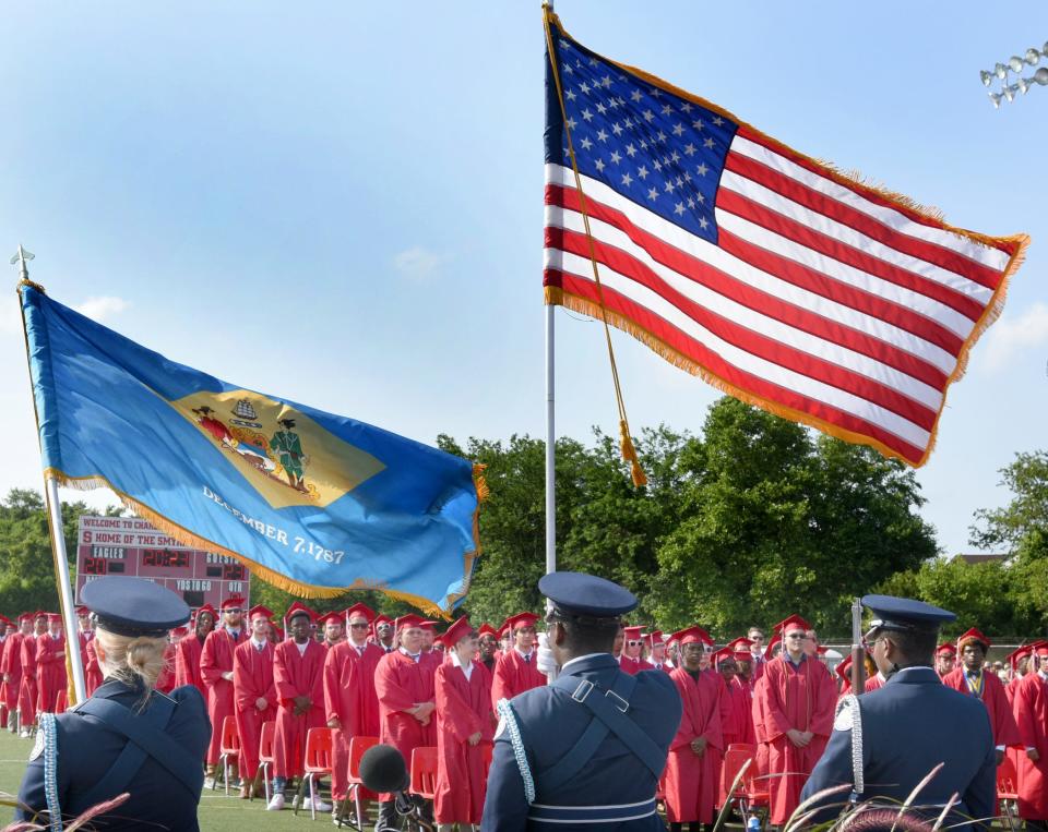 Graduating seniors stand for the National Anthem at the start of Smyrna High School's commencement ceremony on Saturday June 3, 2023.
