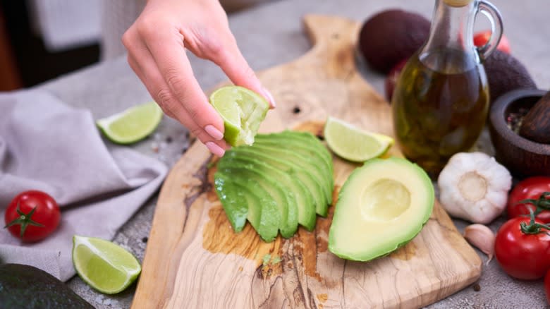 squeezing lime juice over avocado