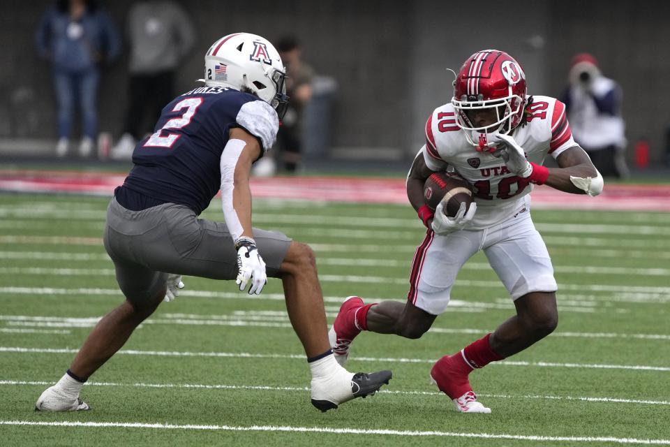 Utah wide receiver Money Parks runs the ball in front of Arizona cornerback Treydan Stukes (2) during the second half of an NCAA college football game, Saturday, Nov. 18, 2023, in Tucson, Ariz. | Rick Scuteri, Associated Press