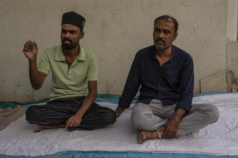 Haji Shamdar, right, who lost his daughter, and Arif Shamdar, who lost his wife and two children, speak with the Associated Press in Morbi town of western state Gujarat, India, Tuesday, Nov. 1, 2022. “Everyone I loved is dead,” said Shamdar, whose wife Aneesa and children, Aliya and Afreed, died in a bridge that collapsed on Sunday. (AP Photo/Rafiq Maqbool)