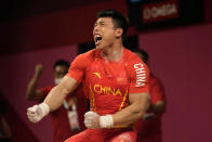 Chen Lijun of China celebrates after winning the gold medal and setting an Olympic record in the men's 67kg weightlifting event, at the 2020 Summer Olympics, Sunday, July 25, 2021, in Tokyo, Japan. (AP Photo/Luca Bruno)