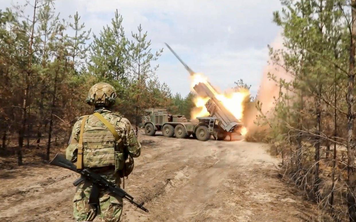 A Russian soldier looks on as the 'Uragan' multiple rocket launcher prepares fires off a missile at an undisclosed location in Russia