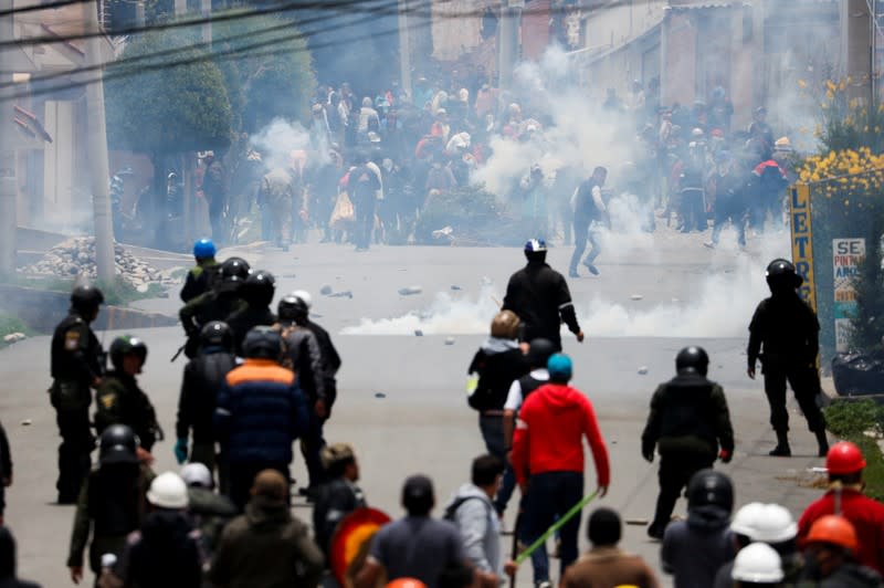 Supporters of Bolivian President Evo Morales and opposition supporters clash during a protest after Morales announced his resignation on Sunday, in La Paz