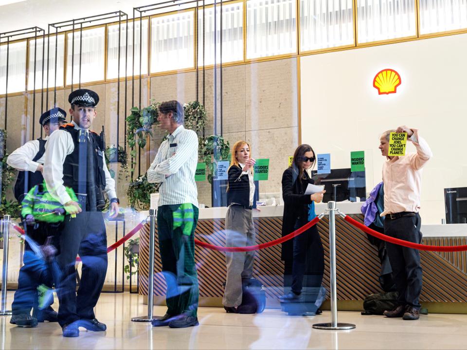 Activists stick ‘insiders wanted’ posters on Shell HQ reception desk (Getty Images)