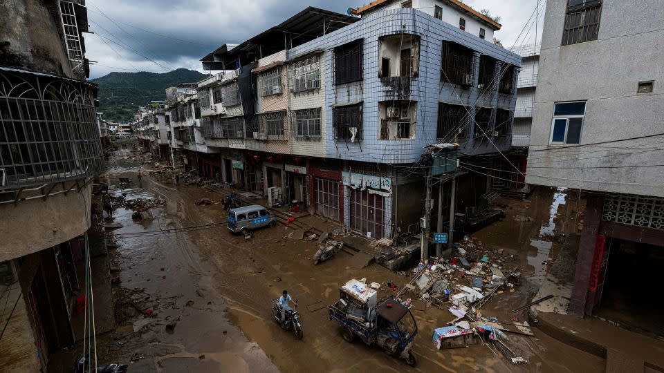 Un hombre conduce por una calle embarrada tras las inundaciones provocadas por las fuertes tormentas en Meizhou, provincia de Guangdong, el mes pasado. - AFP/Getty Images