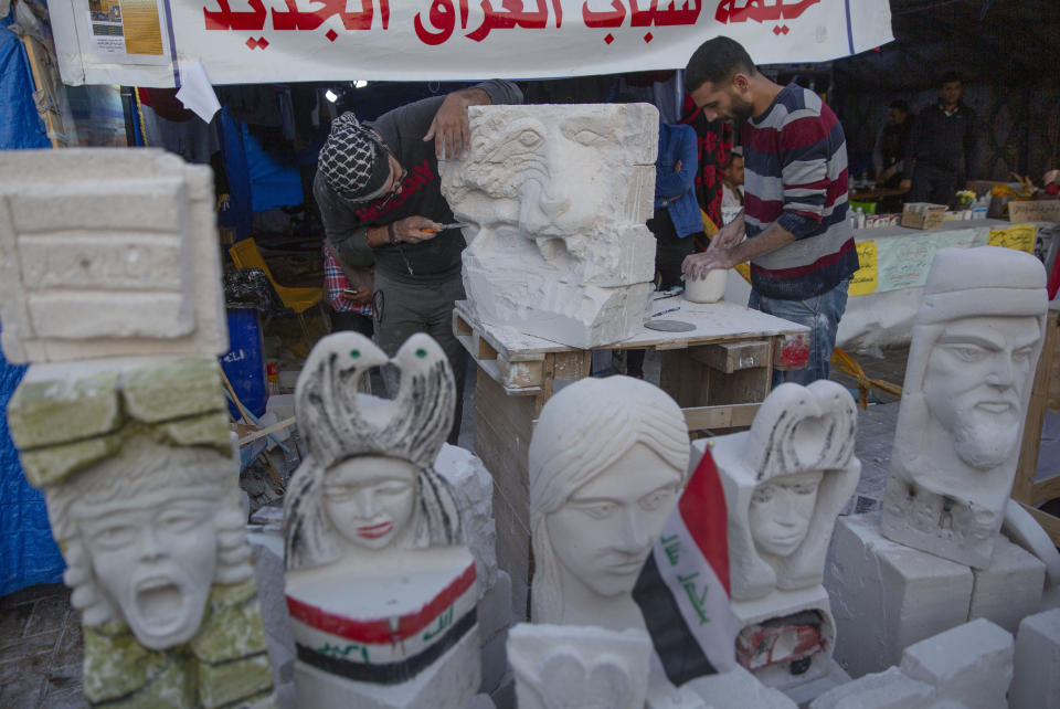 In this Tuesday, Dec. 17, 2019, photo, young Iraqi trainees work on sculptures in preparation for their upcoming art exhibition during the ongoing protests in Tahrir square, Baghdad, Iraq. Tahrir Square has emerged as a focus of the protests, with protesters camped out in dozens of tents. Dozens of people took part in the simple opening of the sculpture exhibition. (AP Photo/Nasser Nasser)