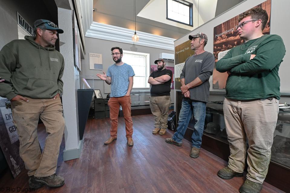 Fort Ritchie employees Jeremy Churnesky, left, museum director Landon Grove, Brandon Byers, Randy Williams and Ian Bercaw talk inside Ritchie History Museum.