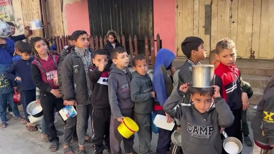 PHOTO: Gazan children wait in a long line for food. (ABC News)