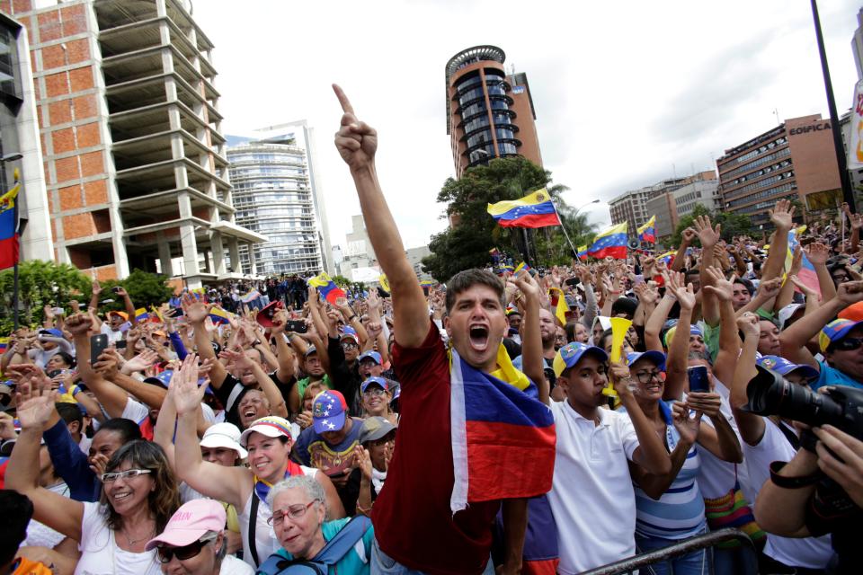Anti-government protesters cheer after Juan Guaido, head of Venezuela's opposition-run congress, declares himself interim president of the South American country until a new election can be called, at a rally demanding the resignation of President Nicolas Maduro, in Caracas, Venezuela, Wednesday, Jan. 23, 2019.