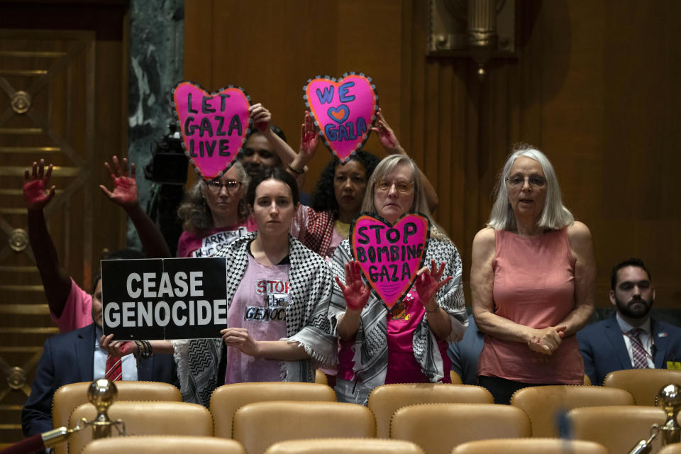 Protestors opposed to the war between Israel and Hamas stand before a hearing of the Senate Appropriations Committee Subcommittee on Defense with Secretary of Defense Lloyd Austin and Chairman of the Joint Chiefs of Staff Air Force Gen. CQ Brown on Capitol Hill, Wednesday, May 8, 2024, in Washington. (AP Photo/Mark Schiefelbein)