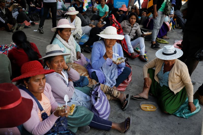 Coca farmers and supporters of Bolivia's ousted President Evo Morales have lunch as they stage a blockade of an entrance to Sacaba