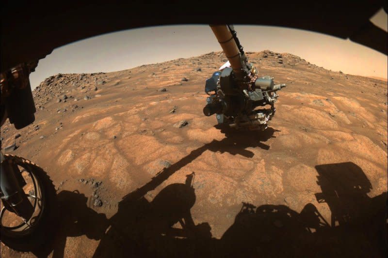 The robotic arm on NASA's Perseverance rover reached out to examine rocks in an area on Mars nicknamed the "Cratered Floor Fractured Rough" area in this image captured on July 10, 2021 The image was processed to enhance contrast. Photo courtesy of NASA