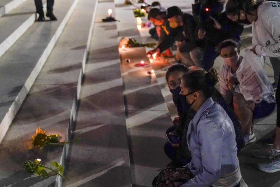 People lay flowers and light candies outside the Supreme Court Friday, Sept. 18, 2020, in Washington, after the Supreme Court announced that Supreme Court Justice Ruth Bader Ginsburg died of metastatic pancreatic cancer at age 87. (AP Photo/Alex Brandon)