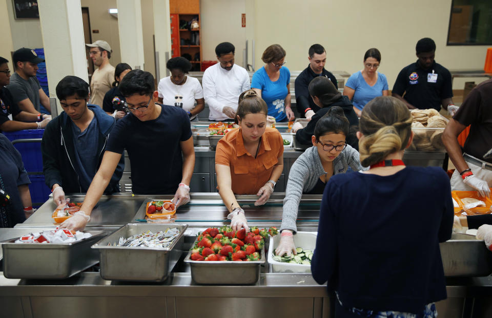 In this March 26, 2019, photo, volunteers put together food trays at Three Square, a food bank in Las Vegas. The reduction of food waste has taken hold in a city known for excess: Las Vegas. Sin City’s world-famous casinos in recent years have developed and expanded innovative practices to cut back on the leftover and uneaten food they send to the landfill by thousands of tons a year. In 2016, MGM began donating fully cooked but never-served meals from conventions and other large events to Three Square, southern Nevada’s only food bank. (AP Photo/John Locher)