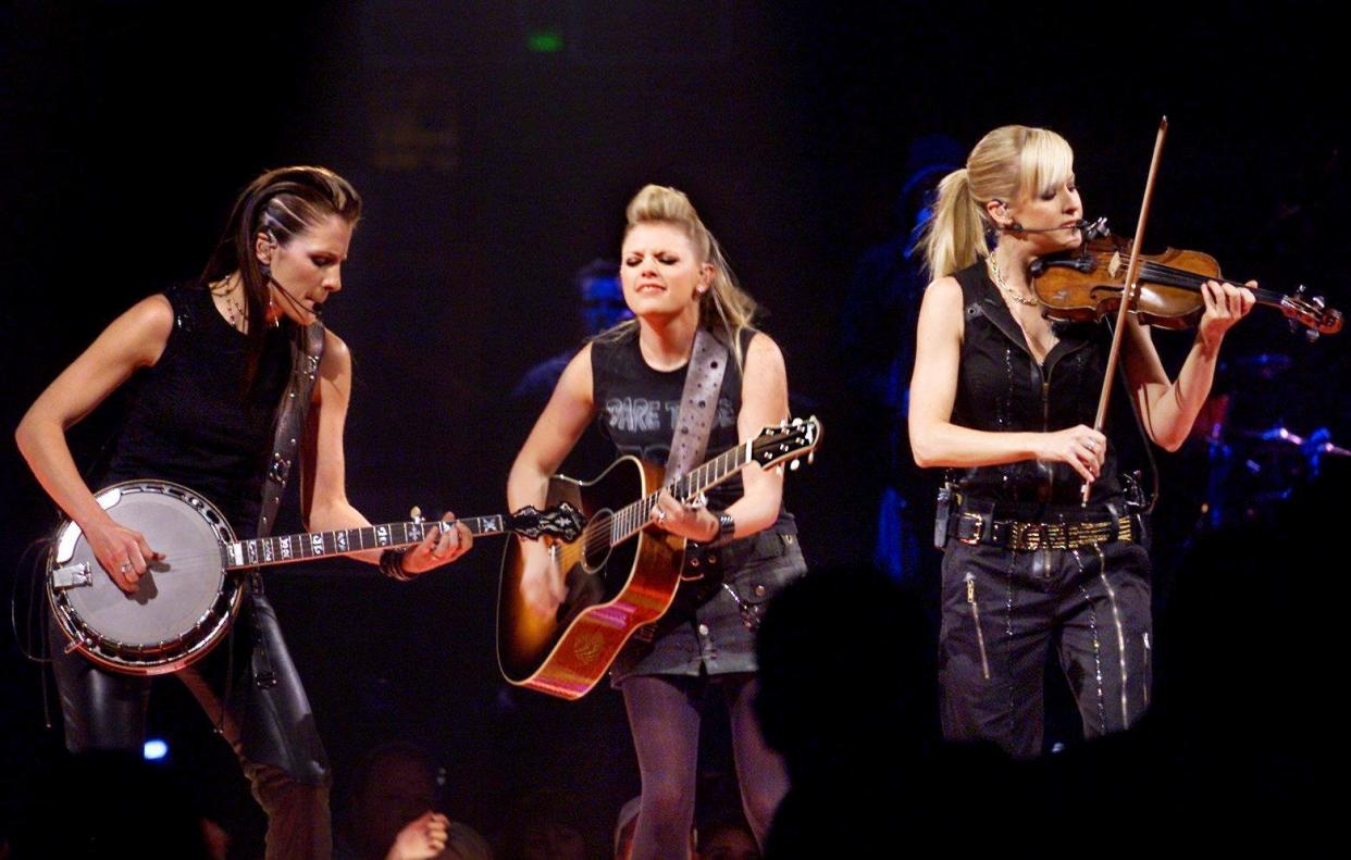 The Dixie Chicks, Emily Robison, left, Natalie Maines and Martie Maguire, perform to an enthusiastic crowd at the Gaylord Entertainment Center in Nashville during their concert on Aug. 4, 2003.