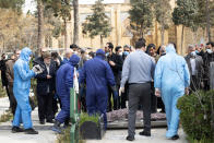 The body of Fatemeh Rahbar, a lawmaker-elect from a Tehran constituency, who died on Saturday after being infected with the new coronavirus, lies on the ground prior to her burial, at Behesht-e-Zahra cemetery, just outside Tehran, Iran, Sunday, March 8, 2020. Rahbar previously served three terms as lawmaker. With the approaching Persian New Year, known as Nowruz, officials kept up pressure on people not to travel and to stay home. Health Ministry spokesman Kianoush Jahanpour, who gave Iran's new casualty figures Sunday, reiterated that people should not even attend funerals. (Mehdi Khanlari/Fars News Agency via AP)