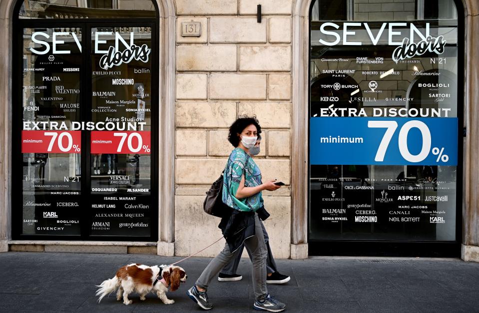 Ciudadanos caminan delante de una tienda de ropa en Roma, Italia. (Foto: VINCENZO PINTO/AFP via Getty Images)