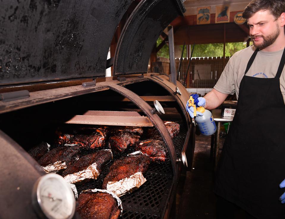 Bobby's BBQ Pit Master Joshua Moore uses an apple cider vinegar to spritz the meat. Spritzing the meat, adds moisture, texture, and helps develop the smokiness of the meats.