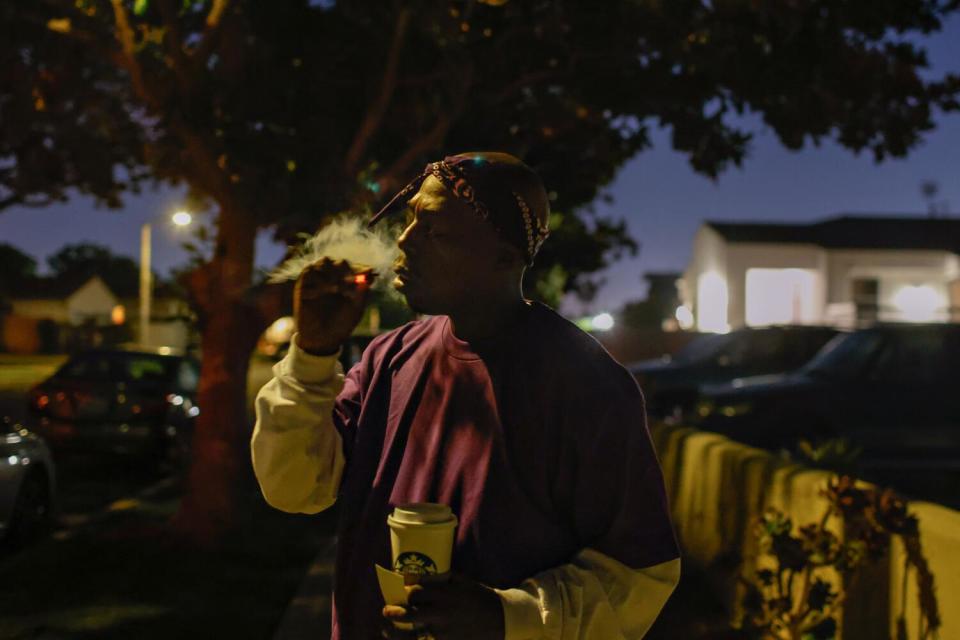 Vincent Hubbard smokes a cigarette in the dark outside a chess tournament.