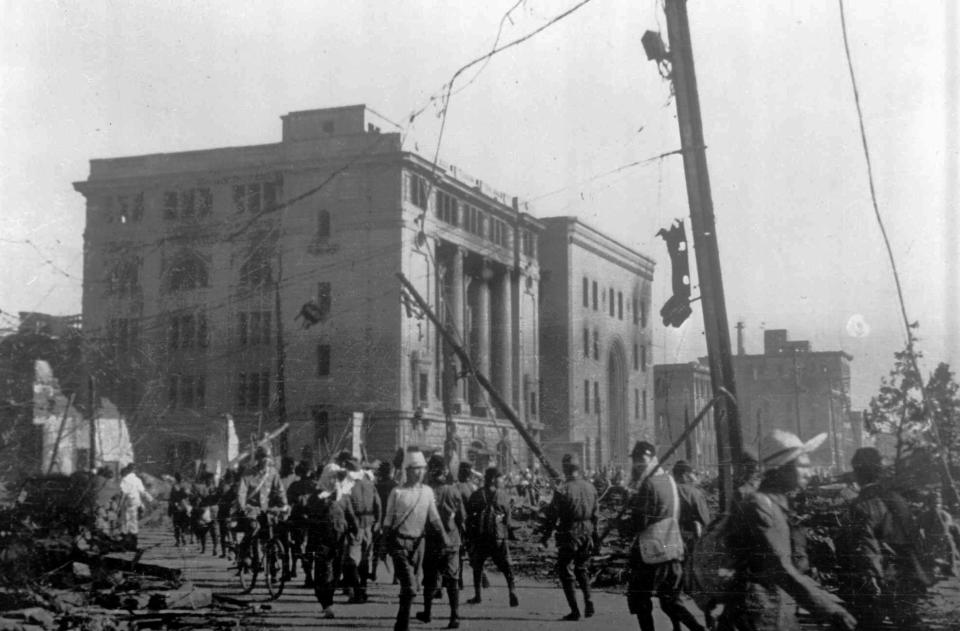 FILE - In this Aug 8, 1945, photo, soldiers and civilians walk through the grim remains of Hiroshima, western Japan, two days after the atomic bomb explosion. The building on left with columned facade was the Hiroshima Bank. To its right, with arched front entrance, was the Sumitomo Bank. An estimated 140,000 people, including those with radiation-related injuries and illnesses, died through Dec. 31, 1945. That was 40% of Hiroshima’s population of 350,000 before the attack. (AP Photo, File)