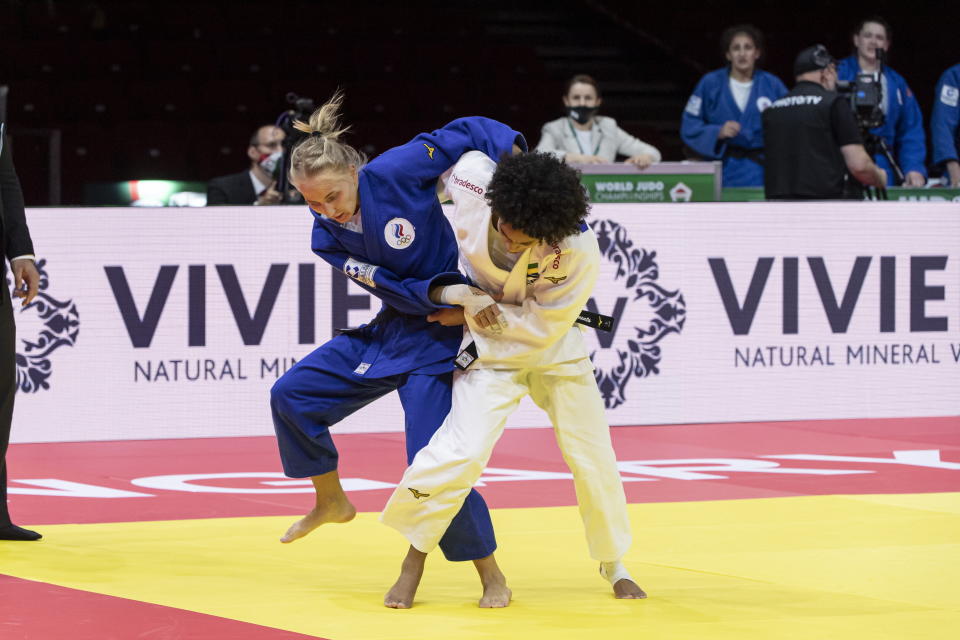 FILE - Ketelyn Nascimento, in white, of Brazil fights against Anastasiia Konkina of Russia in their bronze bout in the mixed team competition of 57kg category at World Judo Championships in Papp Laszlo Budapest Sports Arena, Budapest, Hungary, on June 13, 2021. With just six months to go until the Paris Olympics, it’s still not clear if Russians will be competing and, if so, how many. Russians are qualifying for Olympic spots as “neutral athletes” in combat events such as judo and wrestling. They are not yet in some of the Games’ highest-profile events like track and field, swimming and gymnastics. (Zsolt Szigetvary/MTI via AP, File)