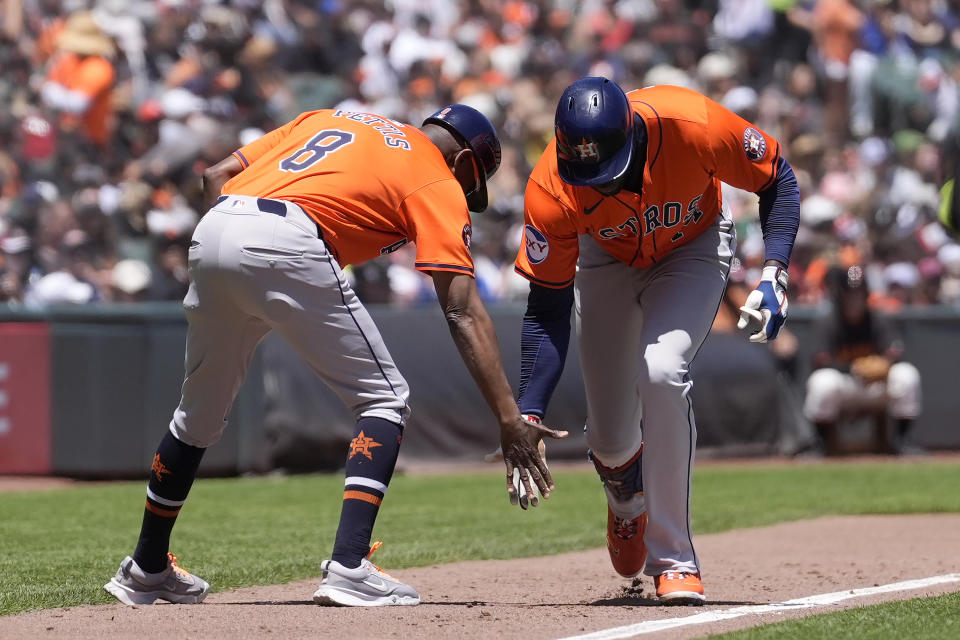 Houston Astros' Yordan Alvarez, right, is congratulated by third base coach Gary Pettis after hitting a two-run home run against the San Francisco Giants during the sixth inning of a baseball game in San Francisco, Wednesday, June 12, 2024. (AP Photo/Jeff Chiu)