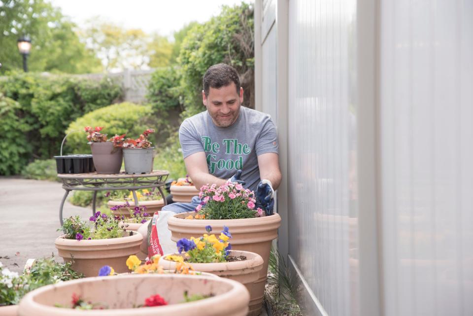 Besa CEO Matthew Goldstein plants flowers at Wexner Heritage Village, a local senior home, in May 2021.
