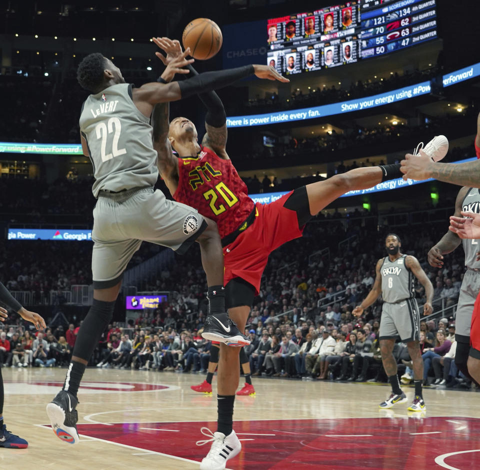 Brooklyn Nets Caris LeVert (22) battles for the ball with Atlanta Hawks John Collins (20) in the second half of an NBA basketball game Friday, Feb. 28, 2020, in Atlanta. (AP Photo/Tami Chappell)