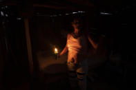 A resident uses a can of benzine for light while electricity is down one week after Hurricane Ian in La Coloma, in Pinar del Rio province, Cuba, after sunset Wednesday, Oct. 5, 2022. (AP Photo/Ramon Espinosa)