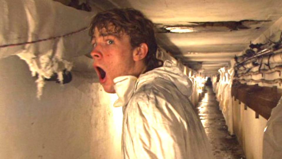 a man screaming in a hallway wearing white in lo-fi horror film