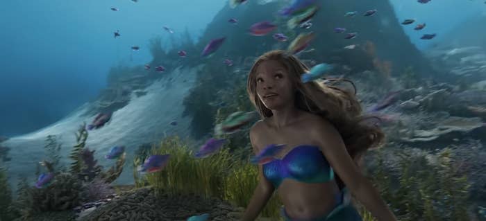 Halle Bailey as Ariel surrounded by a school of fish underwater