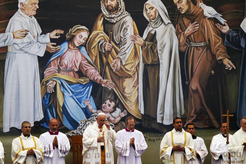 Pope Francis conducts Mass beneath a large mural at Manger Square in Bethlehem