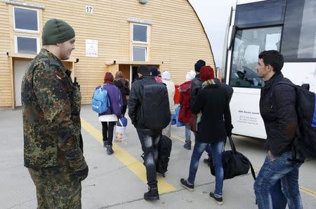 Migrants leave the bus as they arrive to the first registration camp of Erding near Munich, Germany, January 27, 2016. REUTERS/Michaela Rehle