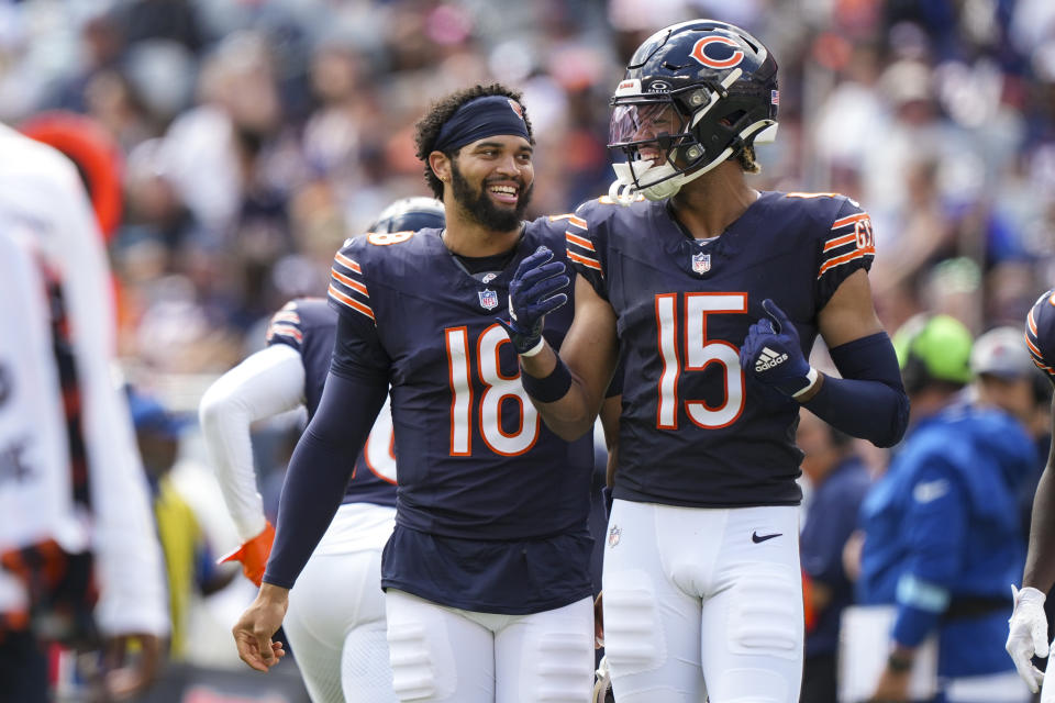 Caleb Williams #18 of the Chicago Bears interacts with Rome Odunze #15 