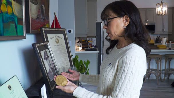 PHOTO: Mallorie Berger, the granddaughter of a Montford Point Marine, holds a replica of the Congressional Gold Medal collectively to the unit in 2011. (ABC News)