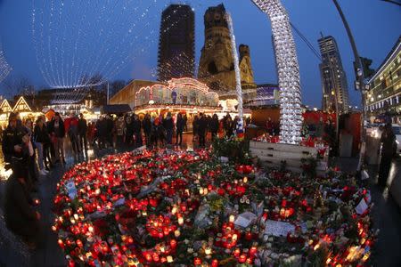 Flowers and candles are placed near the Christmas market at Breitscheid square. REUTERS/Fabrizio Bensch
