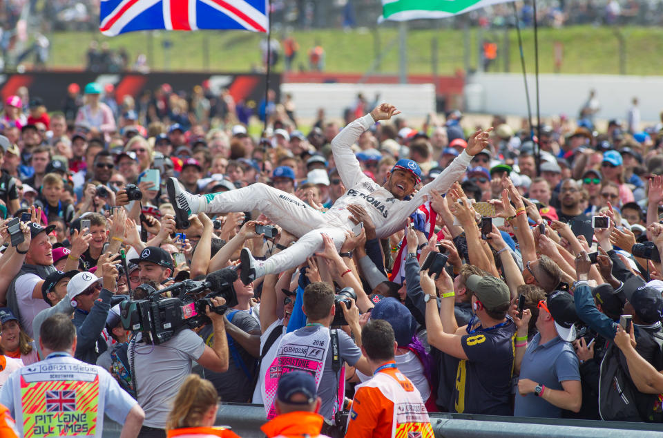 Surf’s up: Lewis Hamilton gets a bit of crowd-surfing in after his 2016 victory at Silverstone