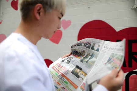 Kyu Cho, 27, reads a newspaper with a front page story about the inter-Korean summit between North Korea's Kim Jong Un and South Korean President Moon Jae-in, in Koreatown, Los Angeles, California, April 27, 2018. REUTERS/Lucy Nicholson