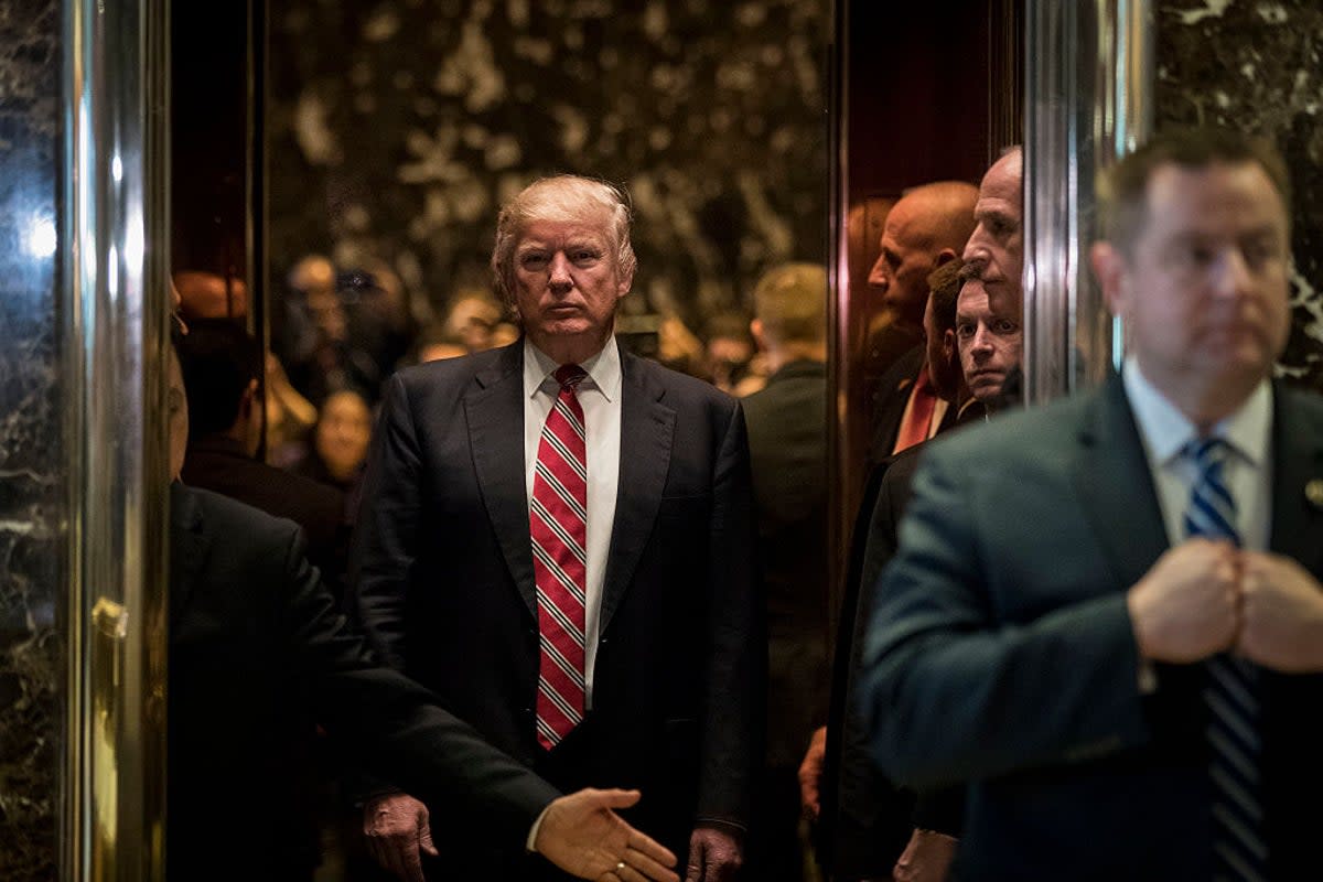 Donald Trump rides the building’s lurid golden elevator  (Getty)