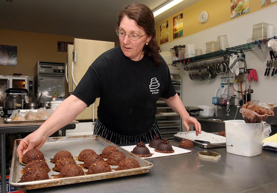 Mary Cesar, owner of Mary's Cakes and Pastries in Northport, arranges mini-cakes in this 2011 file photo. [Staff file photo]