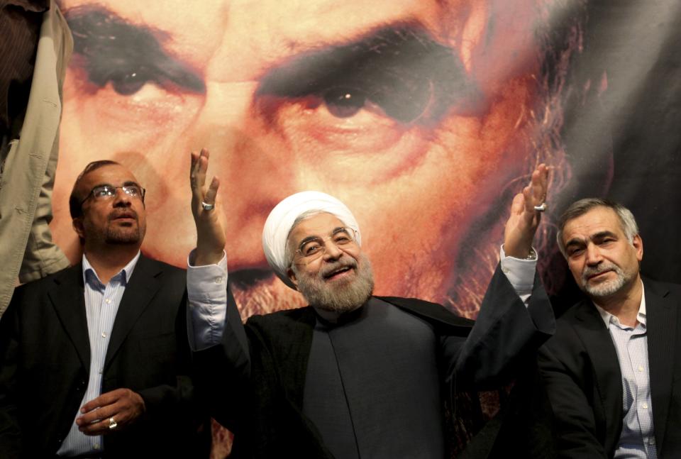  In front of a portrait of the late Iranian revolutionary founder Ayatollah Khomeini, presidential candidate Hasan Rowhani, a former top nuclear negotiator, center, gestures to his supporters at a rally in Tehran, Iran, Saturday, June 1, 2013. (AP Photo/Ebrahim Noroozi, File)