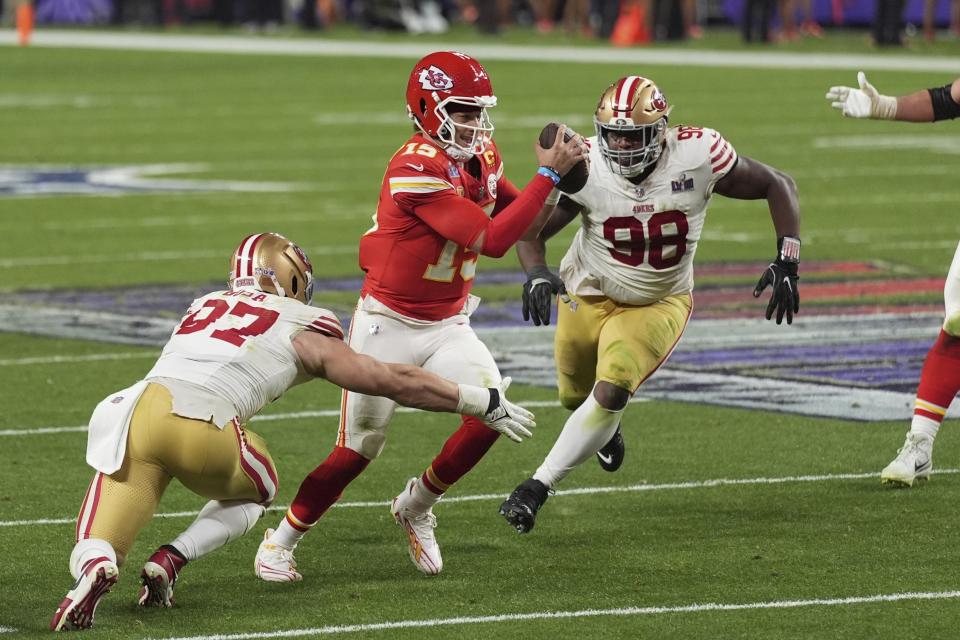 Kansas City Chiefs quarterback Patrick Mahomes (15) scrambles as San Francisco 49ers defensive end Nick Bosa (97) and defensive tackle Javon Hargrave (98) pursue during the second half of the NFL Super Bowl 58 football game Sunday, Feb. 11, 2024, in Las Vegas. (AP Photo/Abbie Parr)