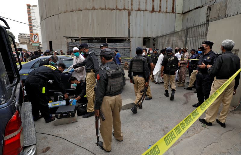 Members of Crime Scene Unit of Karachi Police prepare to survey the site of an attack at the Pakistan Stock Exchange in Karachi
