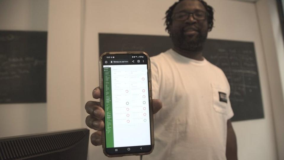 Stanford Mogotsi shows off the app his company designed for Heineken staff