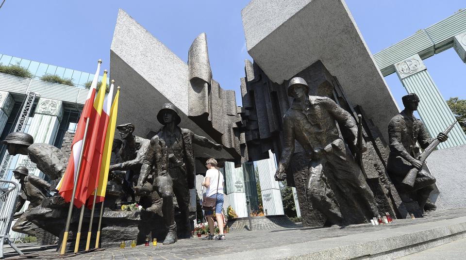 Warsaw residents stop by the monument to the 1944 Warsaw Rising against the occupying Nazis in memory of some 18,000 resistance fighters who fell in the struggle against the German forces and some 180,000 civilians who perished 74 years ago,in Warsaw, Poland, Wednesday, Aug. 1, 2018.(AP Photo/Czarek Sokolowski)